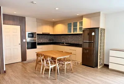 Modern kitchen with wooden dining set and stainless steel appliances in open layout