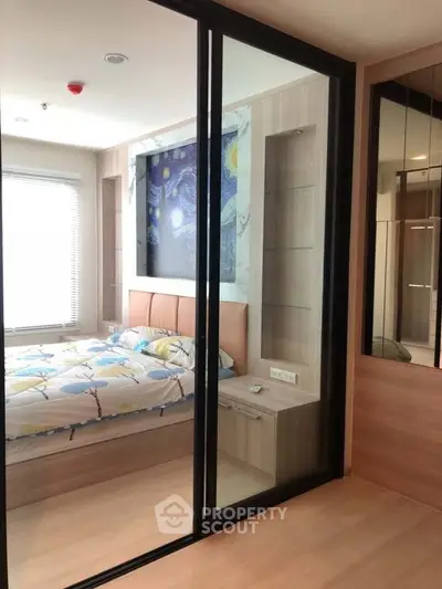 Modern bedroom with glass partition and stylish decor in a cozy apartment.