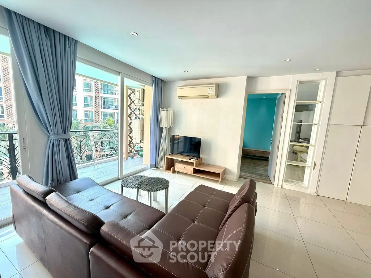 Spacious living room with modern decor and balcony view in luxury apartment.