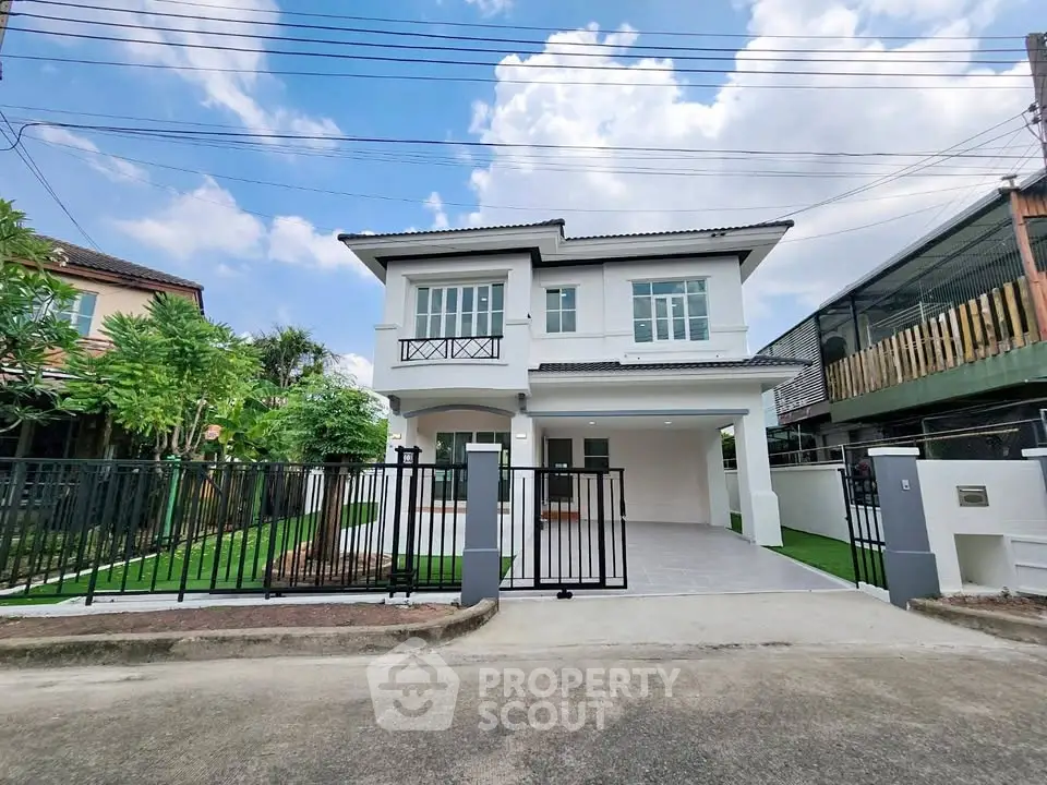 Modern two-story house with gated driveway and lush garden
