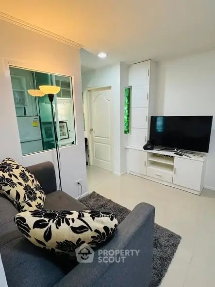 Cozy living room with modern decor, featuring a stylish sofa, TV unit, and elegant lighting.