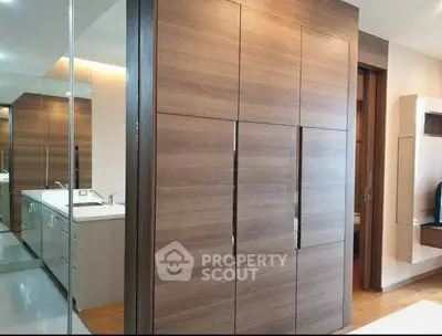 Modern apartment interior with sleek wooden cabinetry and stylish bathroom design.