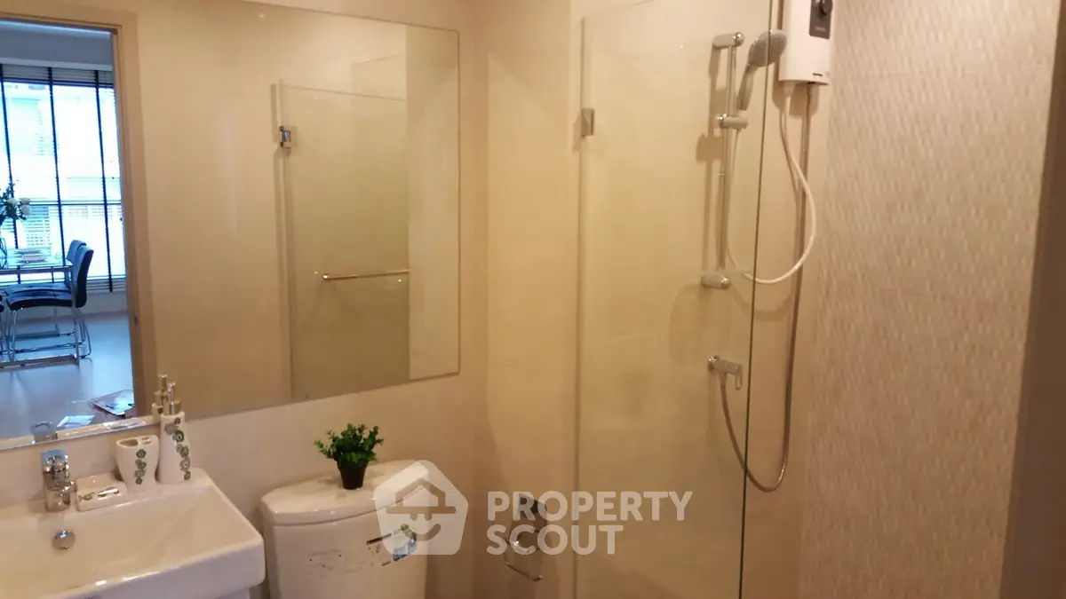 Modern bathroom with glass shower and sleek fixtures in a contemporary apartment.