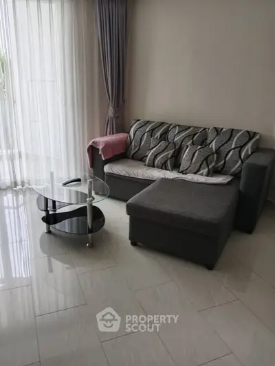 Modern living room with stylish gray sofa and glass coffee table