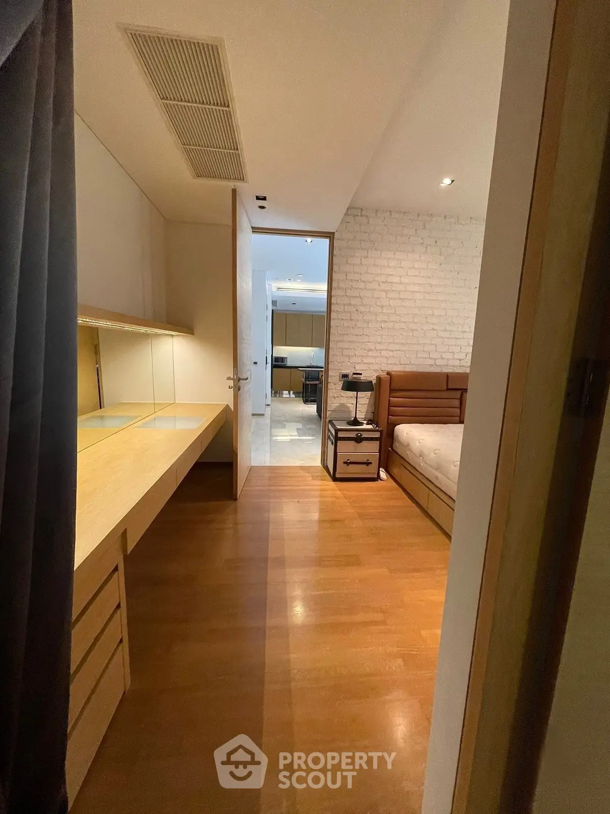 Spacious bedroom with wooden flooring and modern furnishings