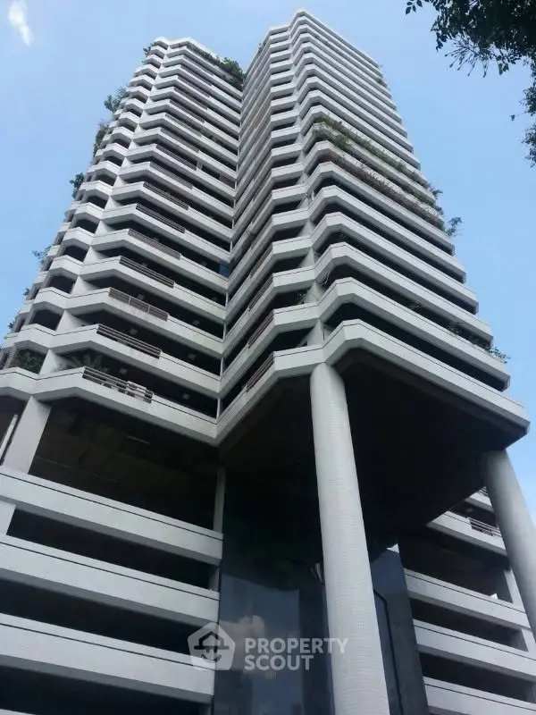 Stunning modern high-rise building with unique architectural design and lush greenery.