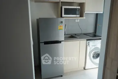 Modern kitchen with stainless steel fridge, microwave, and washing machine