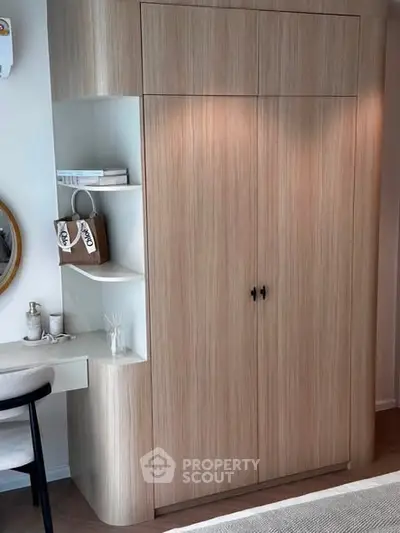 Stylish modern bedroom with built-in wooden wardrobe and cozy workspace.