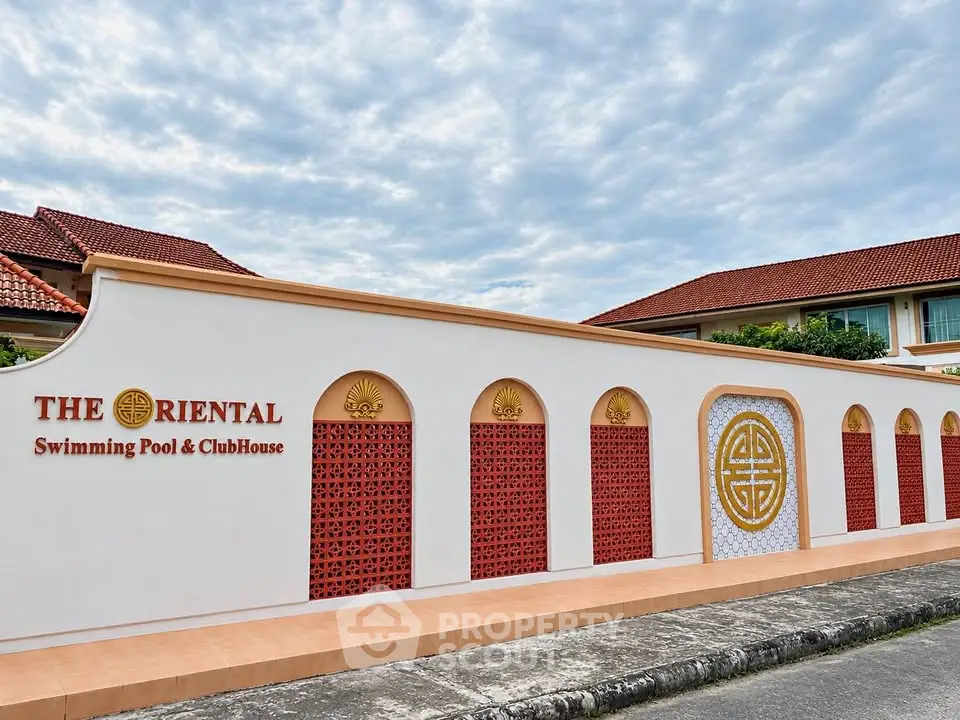 Elegant exterior of The Oriental Swimming Pool & ClubHouse with intricate design and red accents.