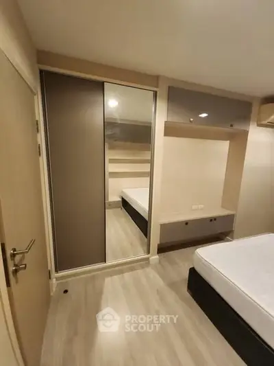 Modern bedroom with sleek design and mirrored wardrobe