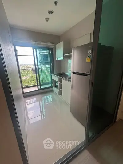 Modern kitchen with sleek appliances and balcony view in urban apartment