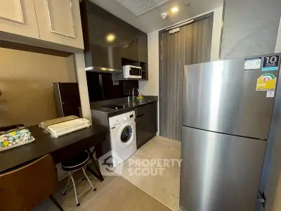 Modern kitchen with sleek appliances and washing machine in compact layout