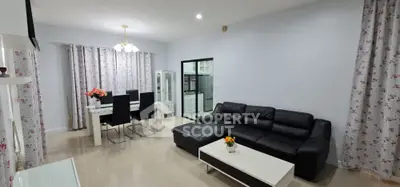 Spacious modern living room with elegant dining area and cozy black leather sofa.
