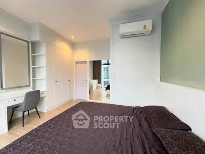 Spacious bedroom with modern furnishings and built-in wardrobe in a stylish apartment.