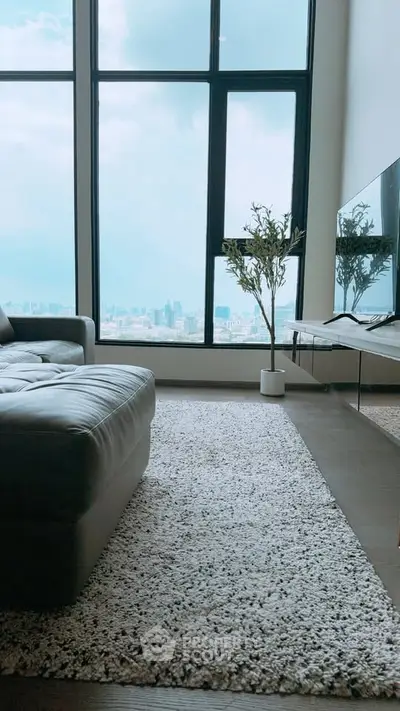 Luxurious living room with floor-to-ceiling windows offering stunning city views, modern decor, and plush seating.