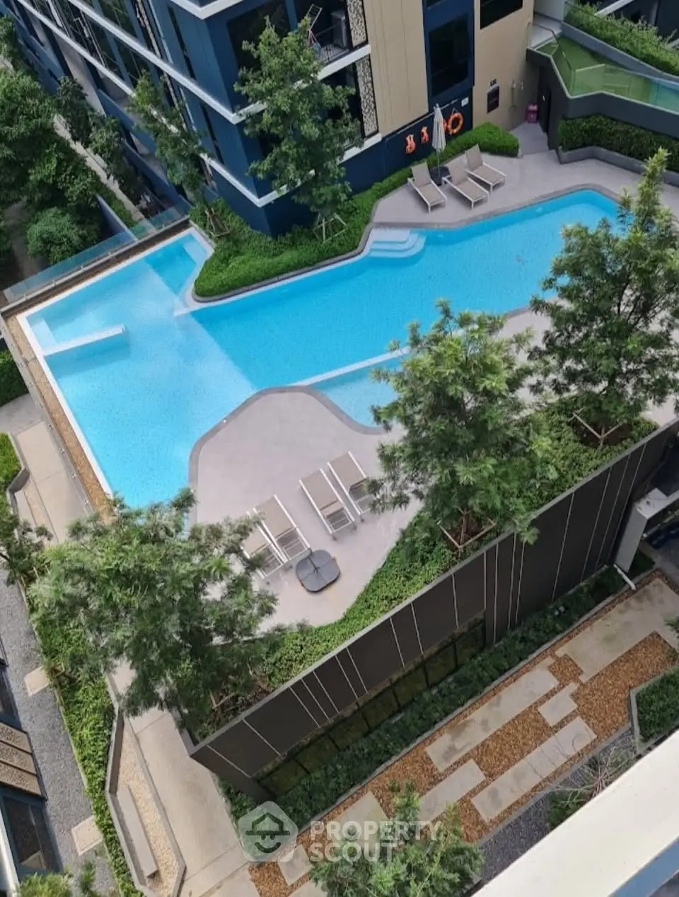 Luxurious modern apartment complex with stunning rooftop pool and lush greenery.