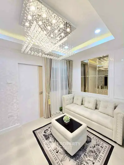 Elegant living room with luxurious chandelier and plush white sofa