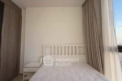 Modern bedroom with minimalist design and large window offering natural light.