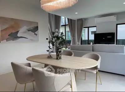 Elegant dining area with modern chandelier and cozy seating in a stylish living room.