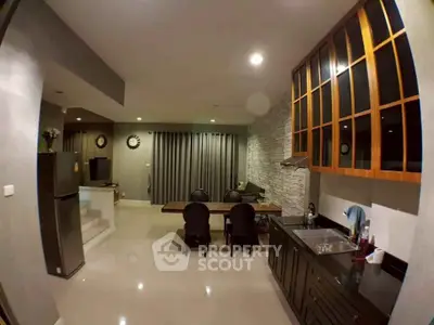 Spacious modern kitchen with open layout and dining area, featuring sleek cabinetry and contemporary decor.