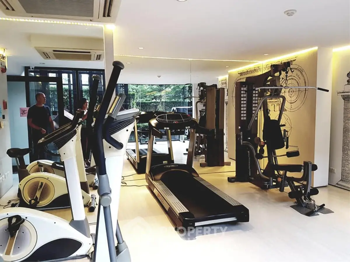 Modern gym with state-of-the-art fitness equipment and mirrored walls in luxury real estate property.