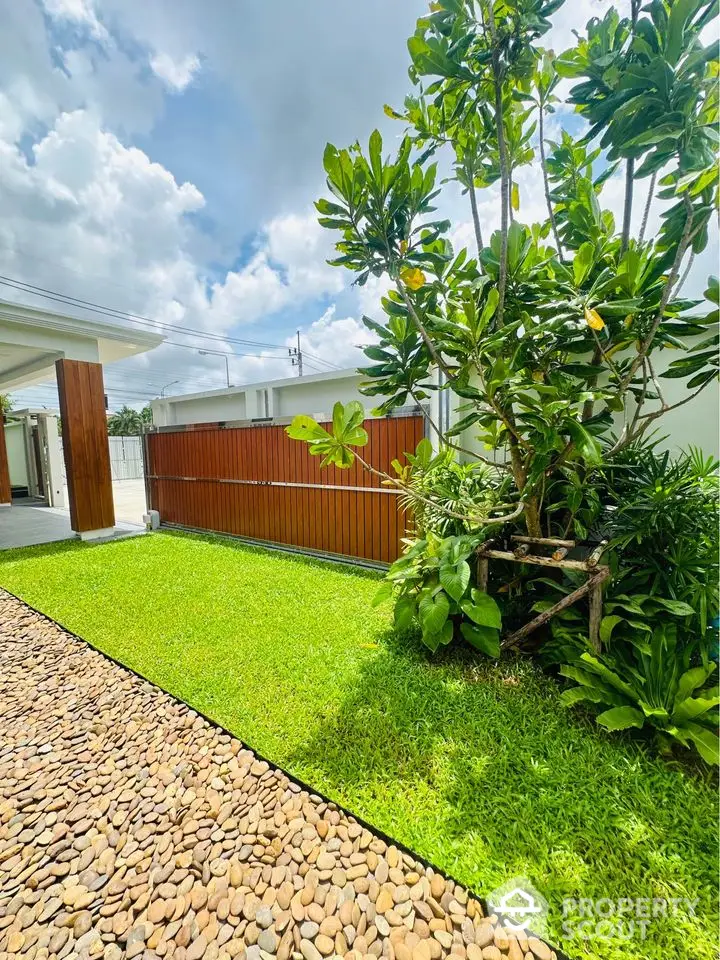 Beautiful garden with lush greenery and stone pathway in modern residential property.