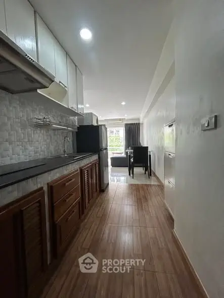 Modern kitchen with sleek cabinetry and open layout leading to dining area, perfect for urban living.