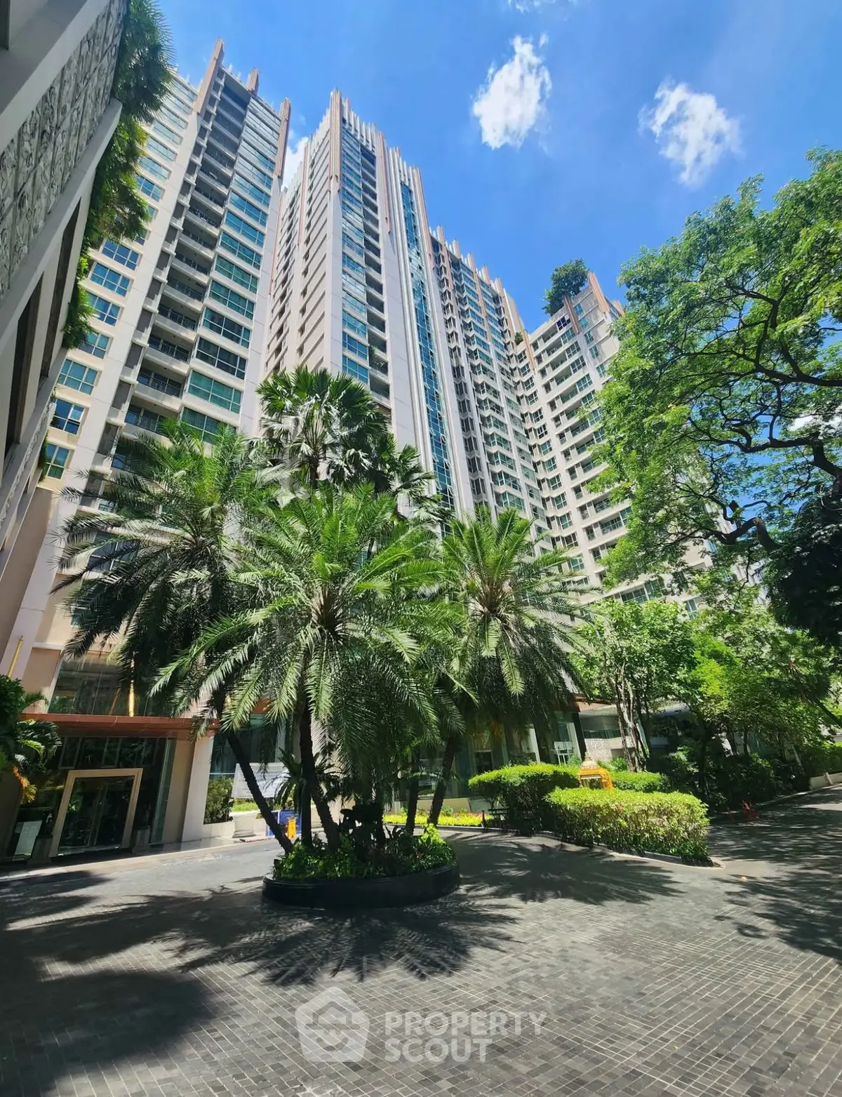 Stunning high-rise building with lush greenery and clear blue sky