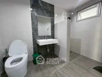 Modern bathroom with sleek design, featuring a wall-mounted sink and stylish tiles.
