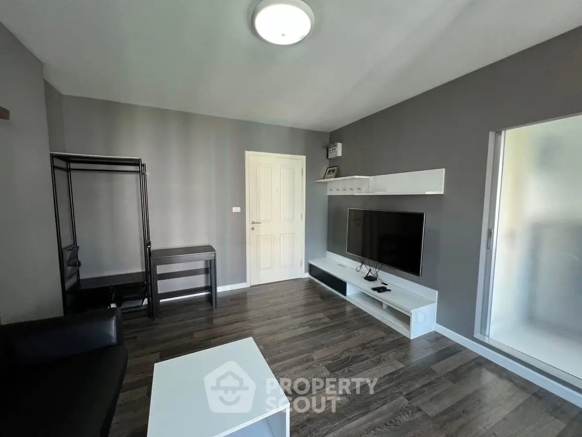 Modern living room with sleek furniture and wall-mounted TV in stylish apartment.