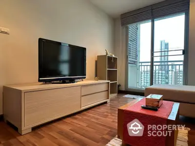 Modern living room with balcony view, featuring sleek furniture and natural light.