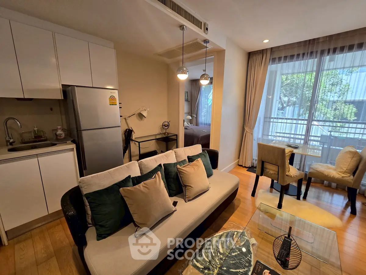 Modern open-plan living room with kitchen and dining area, featuring stylish decor and natural light.