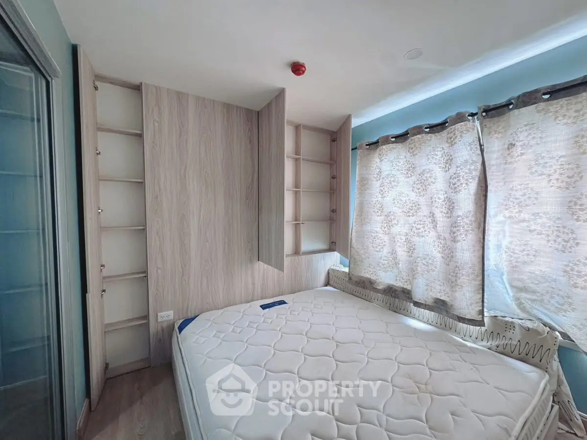 Cozy bedroom with built-in shelves and large window for natural light