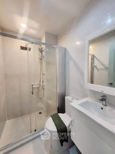 Modern bathroom with glass shower and sleek white fixtures