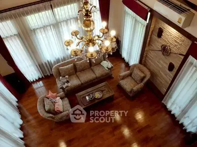 Luxurious living room with elegant chandelier and plush seating in a spacious, well-lit area.