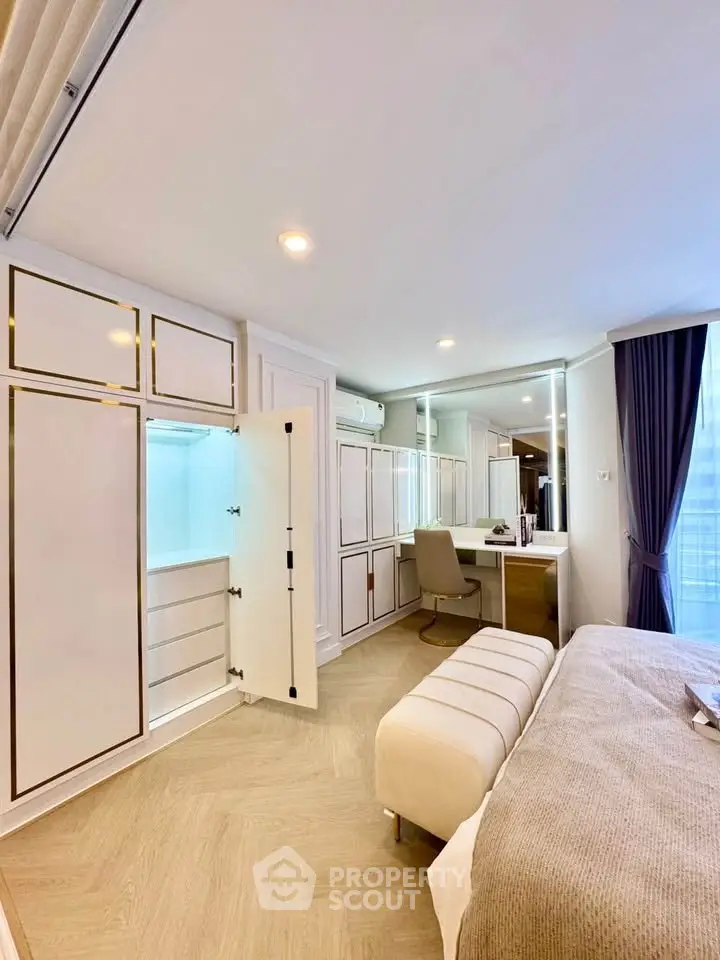 Luxurious bedroom with elegant built-in wardrobe and cozy seating area.