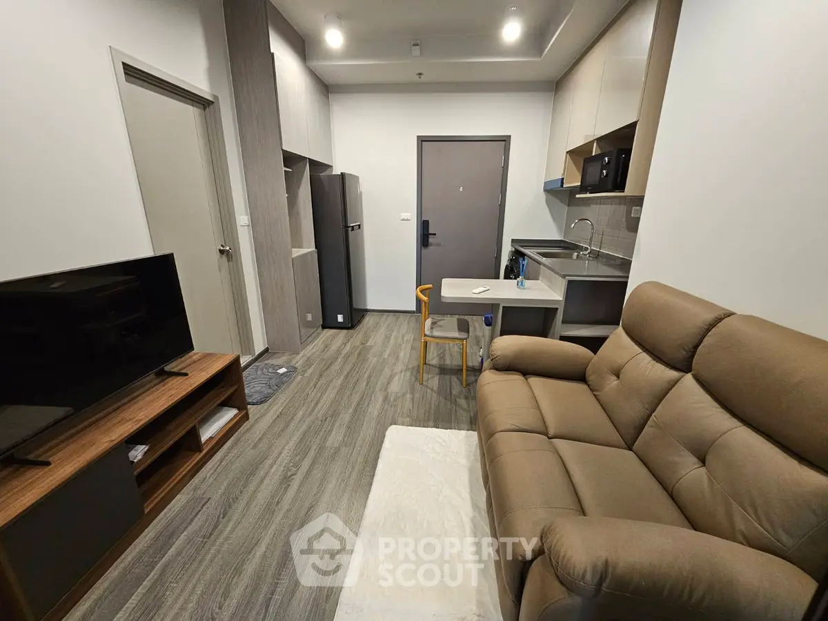 Modern living room with cozy sofa and sleek kitchen area