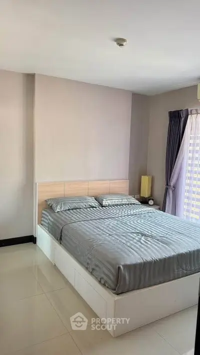 Modern bedroom with sleek design and natural light, featuring a comfortable bed and stylish decor.