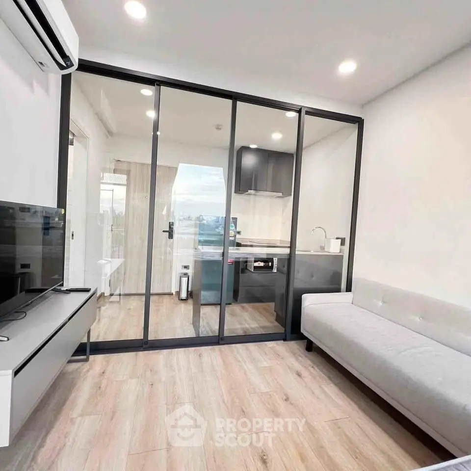 Modern living room with glass partition and sleek kitchen design