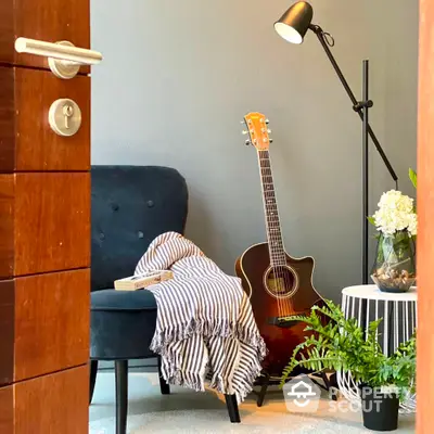 Cozy reading nook with stylish armchair, floor lamp, and acoustic guitar, perfect for relaxation and music enthusiasts.