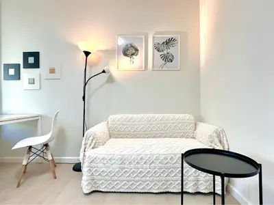 Cozy living room with modern decor, featuring a stylish sofa, elegant lighting, and contemporary wall art.