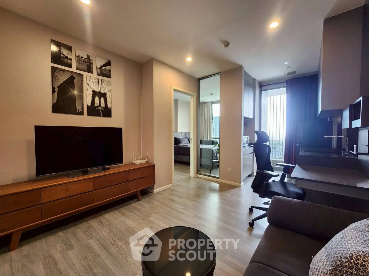 Modern living room with sleek furniture and open layout, featuring a TV and stylish decor.
