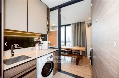 Modern kitchen with washing machine and open layout to dining area