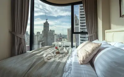 Luxurious bedroom with stunning city view from large window, featuring elegant decor and cozy bedding.