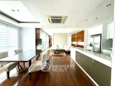 Spacious modern living and dining area with sleek kitchen and wooden flooring