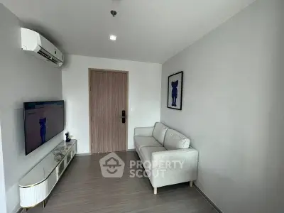 Modern living room with sleek design, featuring a comfortable sofa, wall-mounted TV, and stylish decor.