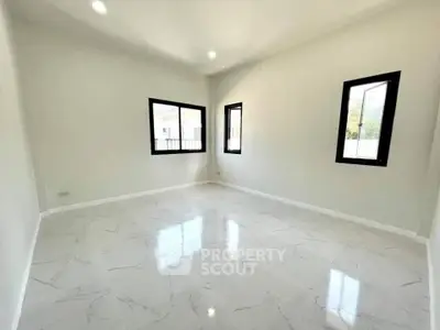 Spacious empty room with large windows and glossy tile flooring, perfect for customization.