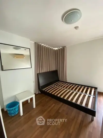 Spacious bedroom with modern bed frame and wooden flooring