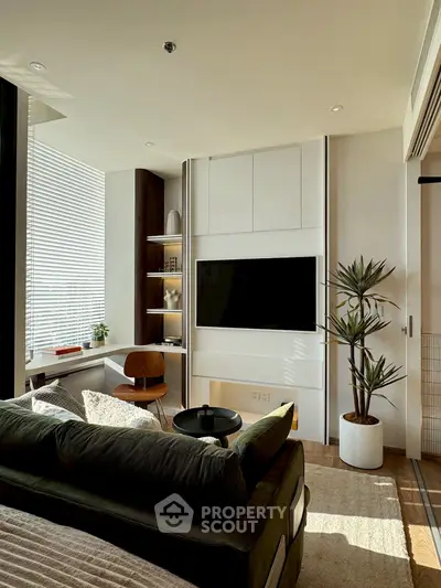 Modern living room with sleek design, featuring a wall-mounted TV, cozy seating, and abundant natural light.