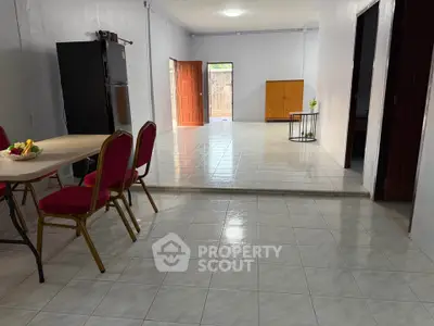 Spacious open-plan living area with tiled flooring and dining setup.